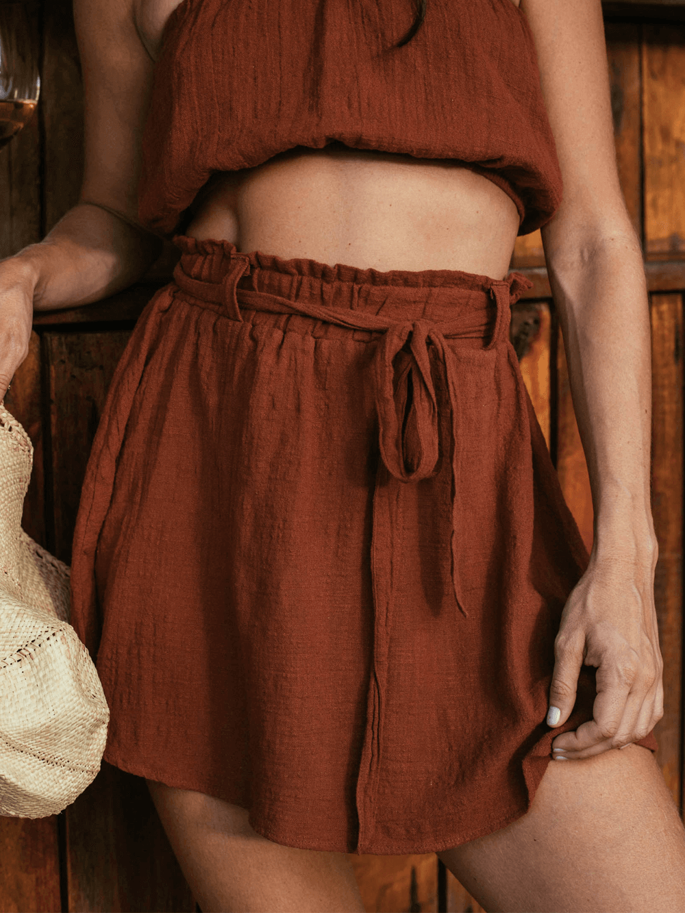 Saia curta Stela Chocolate da Greenish, feita em algodão sustentável, com cós elástico e faixa para amarrar.