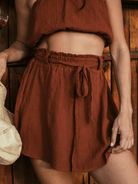 Saia curta Stela Chocolate da Greenish, feita em algodão sustentável, com cós elástico e faixa para amarrar.