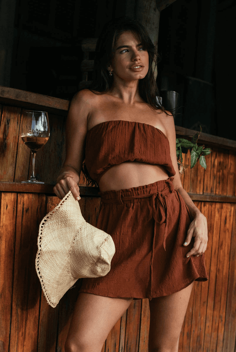 Saia curta Stela da Greenish em tom chocolate, modelo solto com babado e faixa para amarrar, produzido em algodão sustentável.