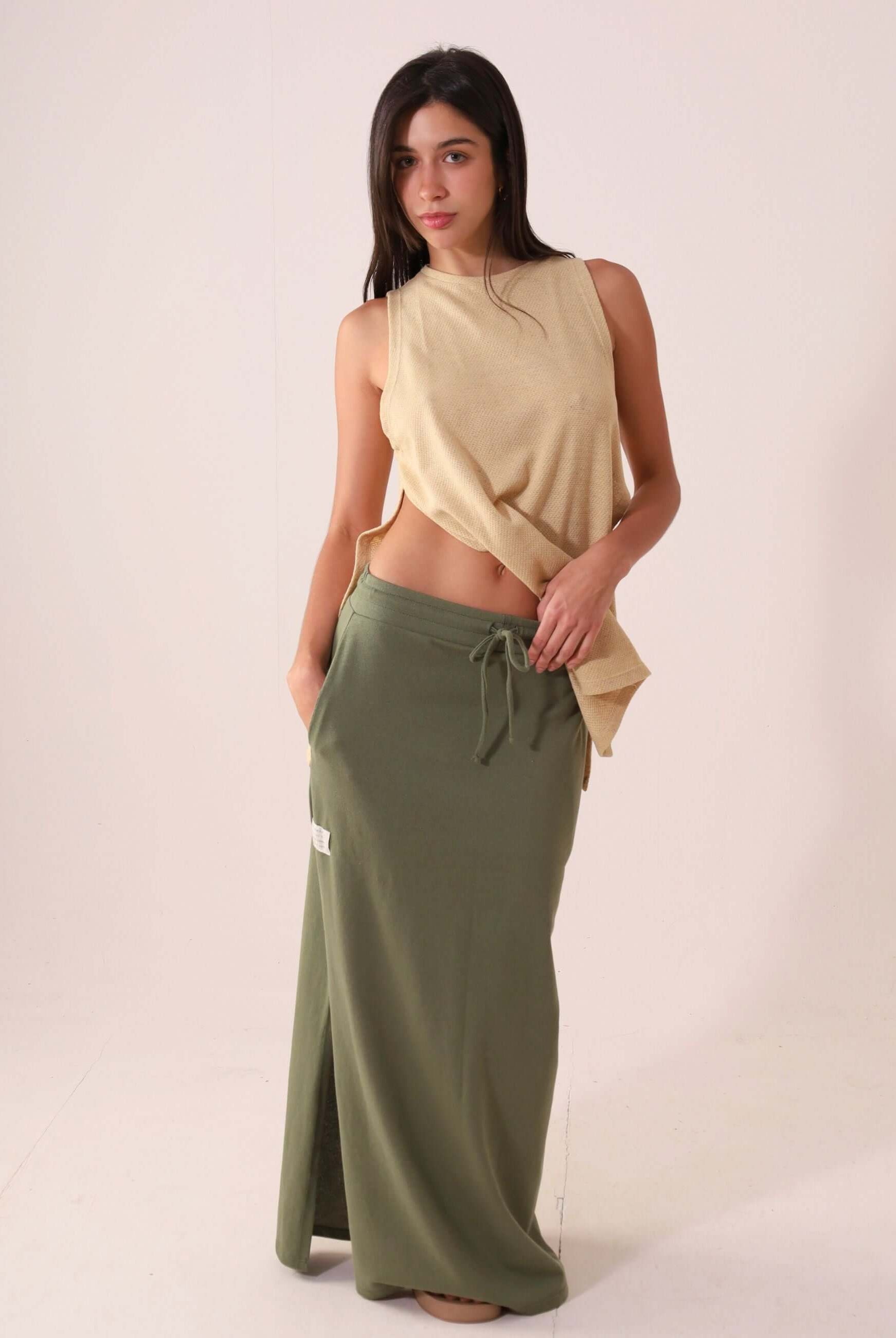 Modelo usando a SAIA MIDI DÉA - VERDE CLARO da Greenish, em malha canelada com cós elástico e fenda lateral para conforto e estilo.