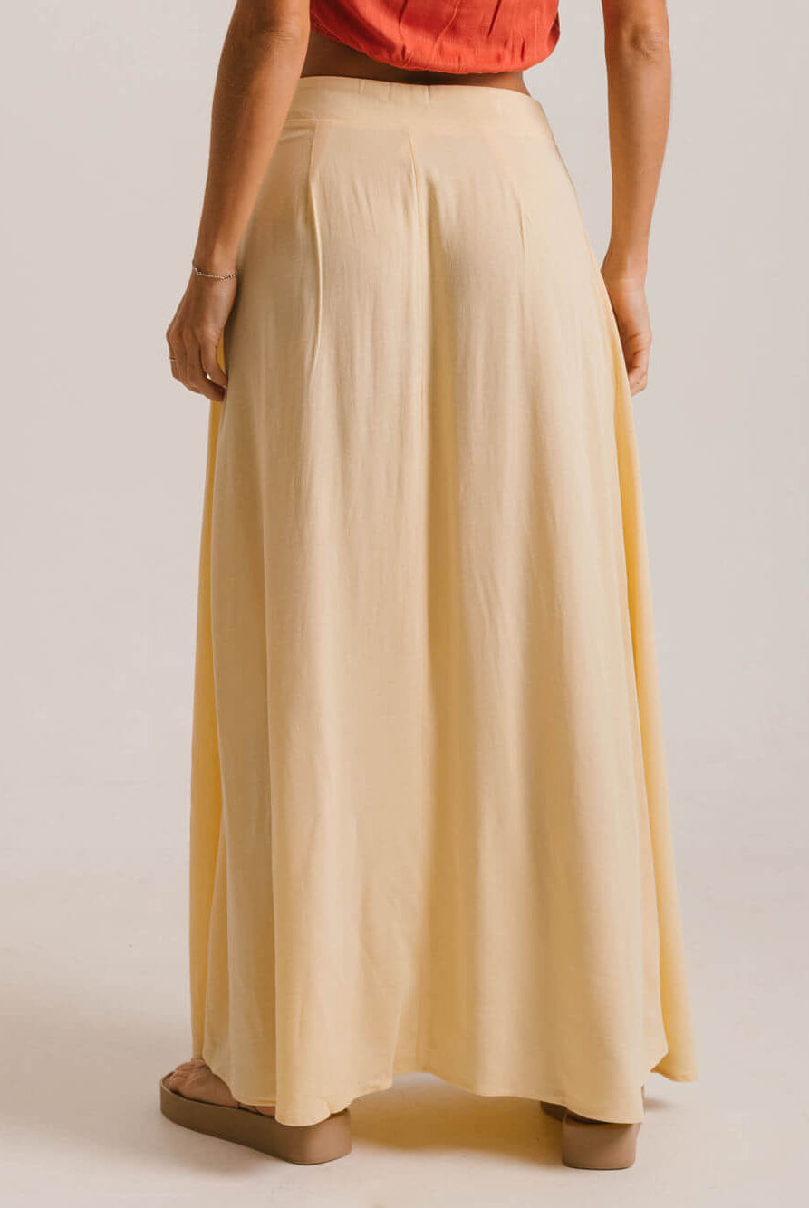 Saia midi Priya da Greenish, bege, com caimento leve e fluído, feita de viscose de reflorestamento.