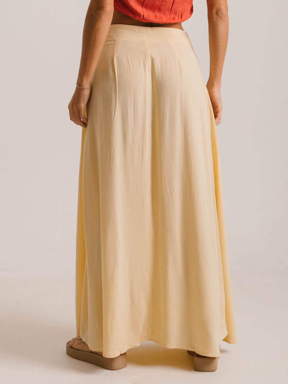 Saia midi Priya da Greenish, bege, com caimento leve e fluído, feita de viscose de reflorestamento.