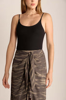 Model wearing a black ribbed tank top with a tie-dye midi skirt, showcasing a stylish, casual look.