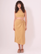 Modelo usando saia midi caqui "Sunny" da Greenish, feita em algodão e com ajuste na cintura, ideal para dias ao ar livre.