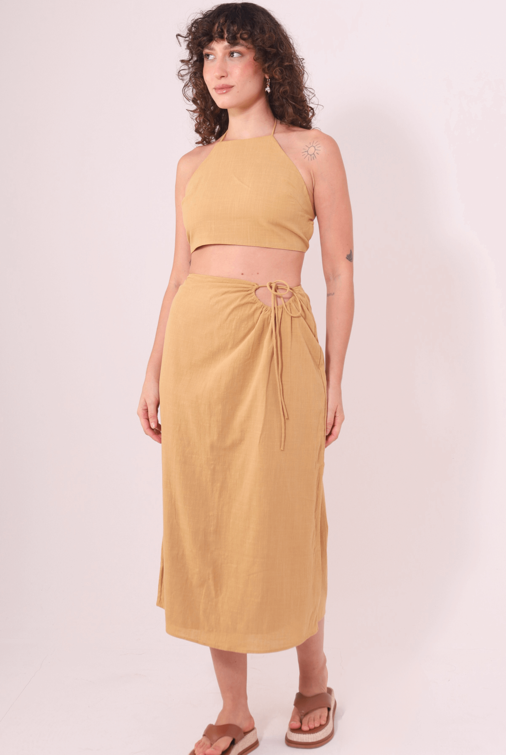 Mulher usando a Saia Midi Sunny Caqui da Greenish, feita em algodão com cós ajustável, destacando conforto e fluidez.