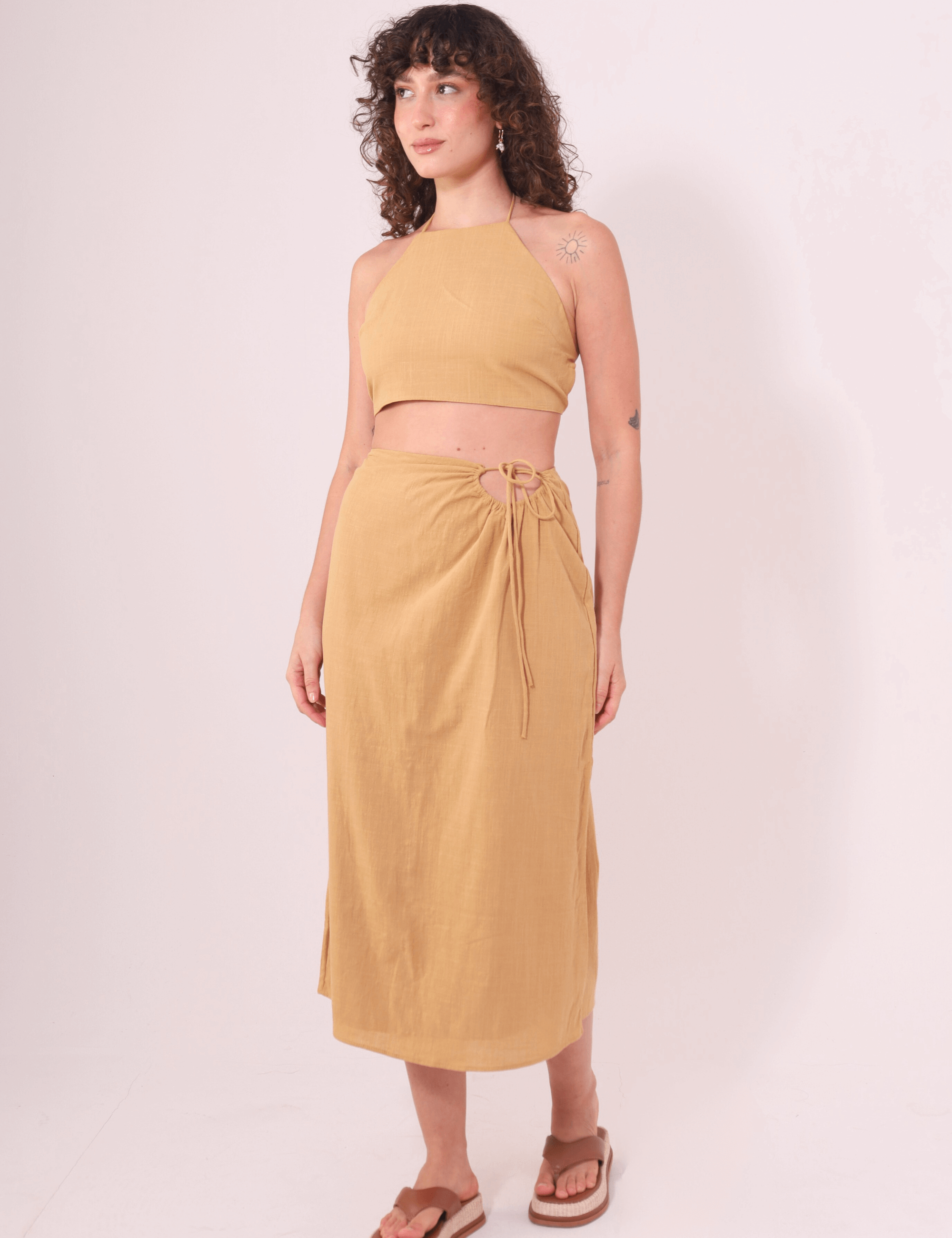 Mulher usando a Saia Midi Sunny Caqui da Greenish, feita em algodão com cós ajustável, destacando conforto e fluidez.