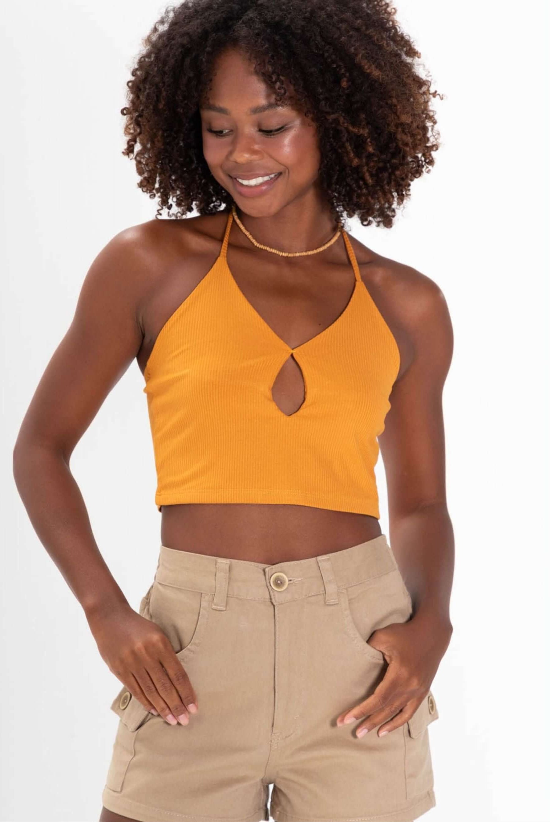 Feminino usando top laranja decotado e short cargo bege da marca Greenish, estilo casual e confortável.