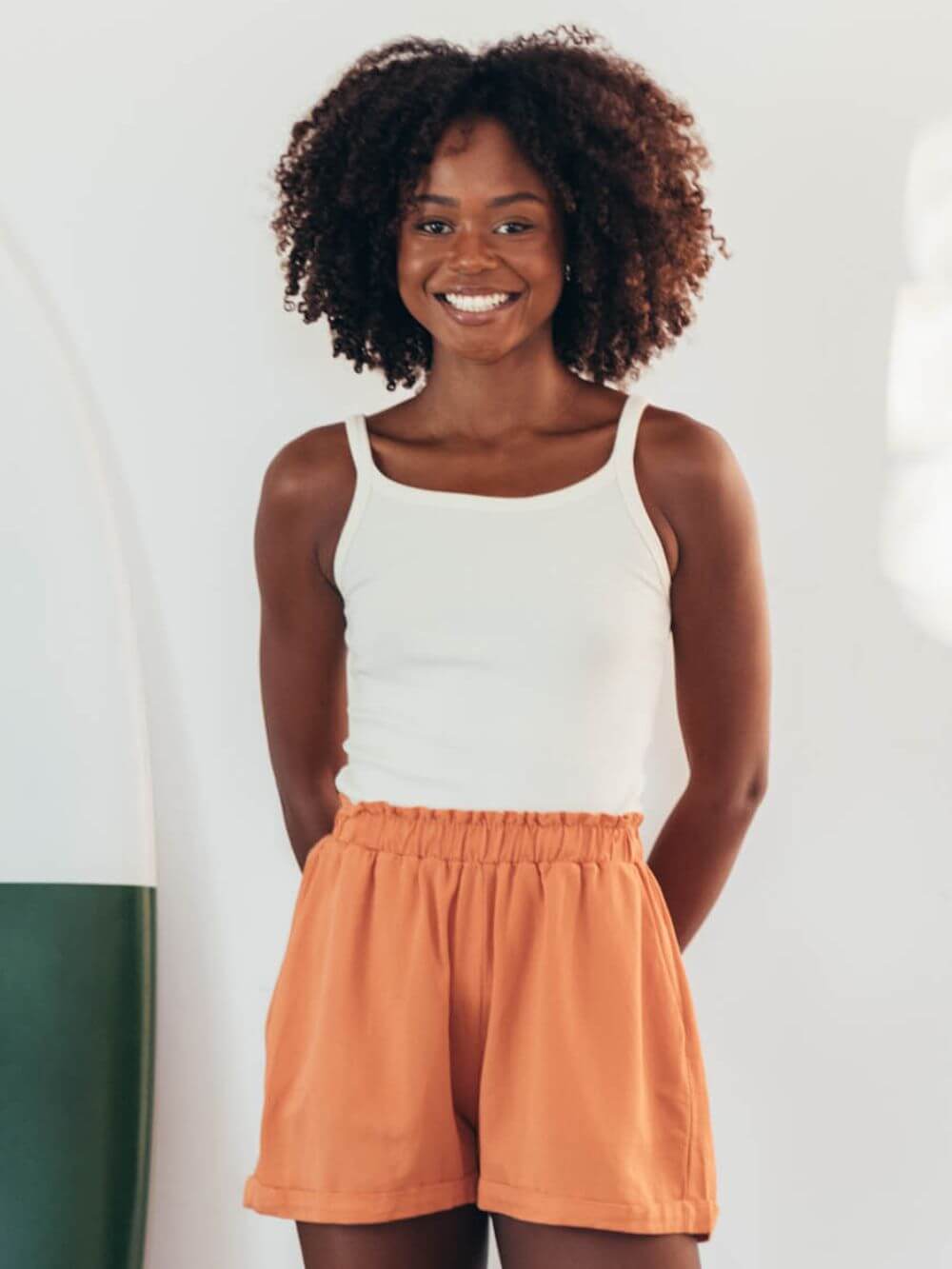 Modelo usando o SHORT DREAM DAYS - LARANJA da Greenish, destacando estilo e conforto para o verão.