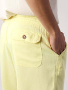 Short Linho Relax Amarelo da Greenish, mostrando bolso traseiro e detalhe em botão. Peça casual e confortável.