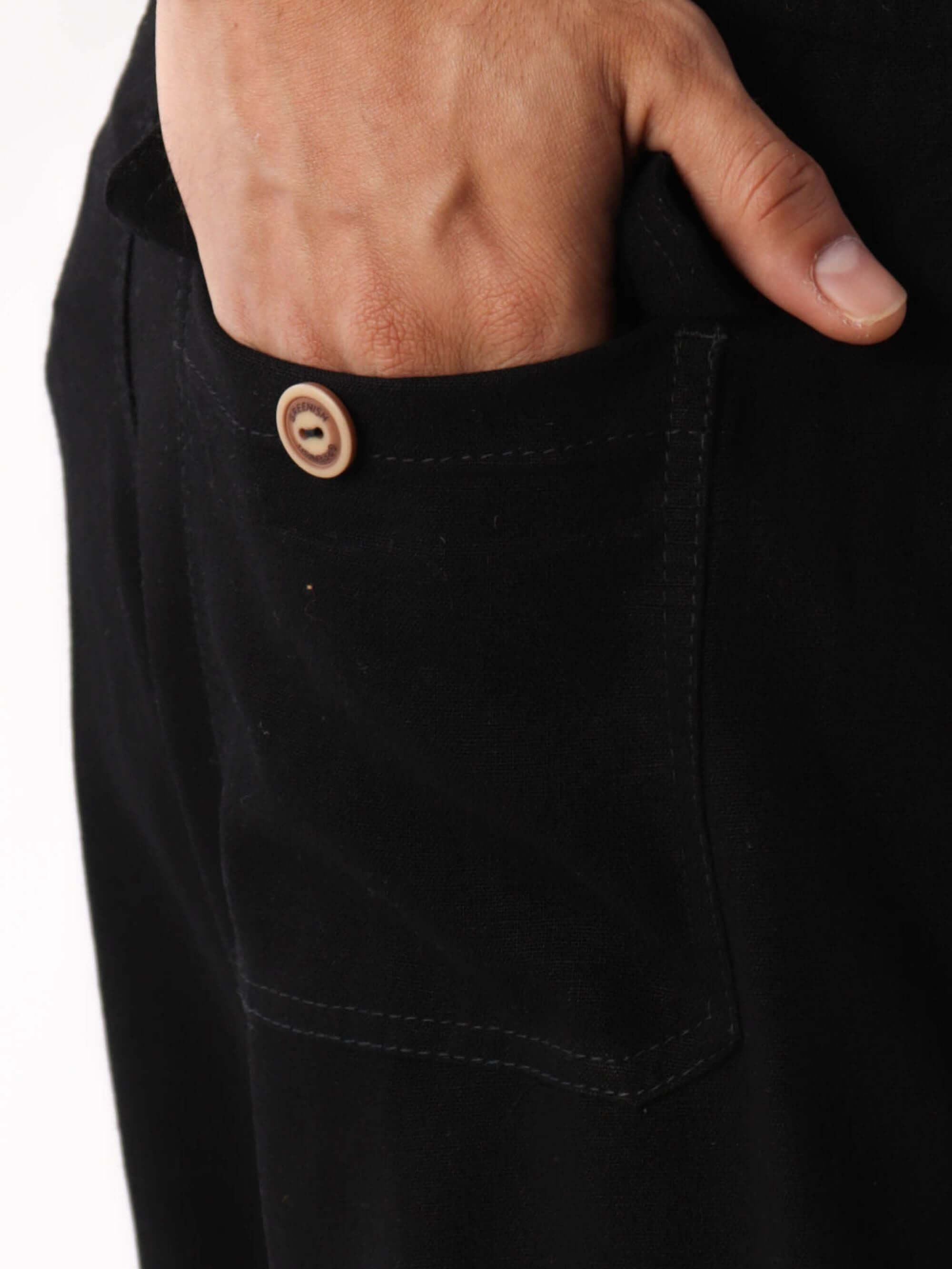 Detalhe do bolso traseiro do Short Linho Relax Preto da Greenish, com botão em madeira.