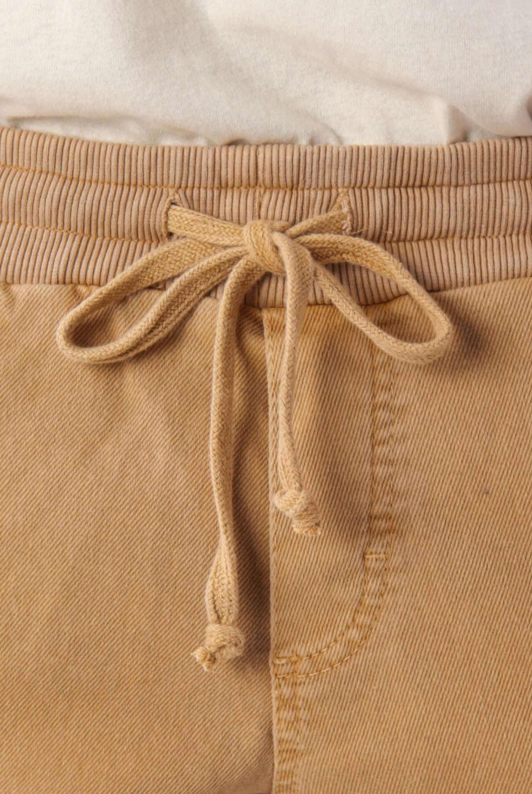 Detalhe do cadarço de algodão do Short Rio Stone - Amarelo da Greenish, ideal para conforto e estilo casual.