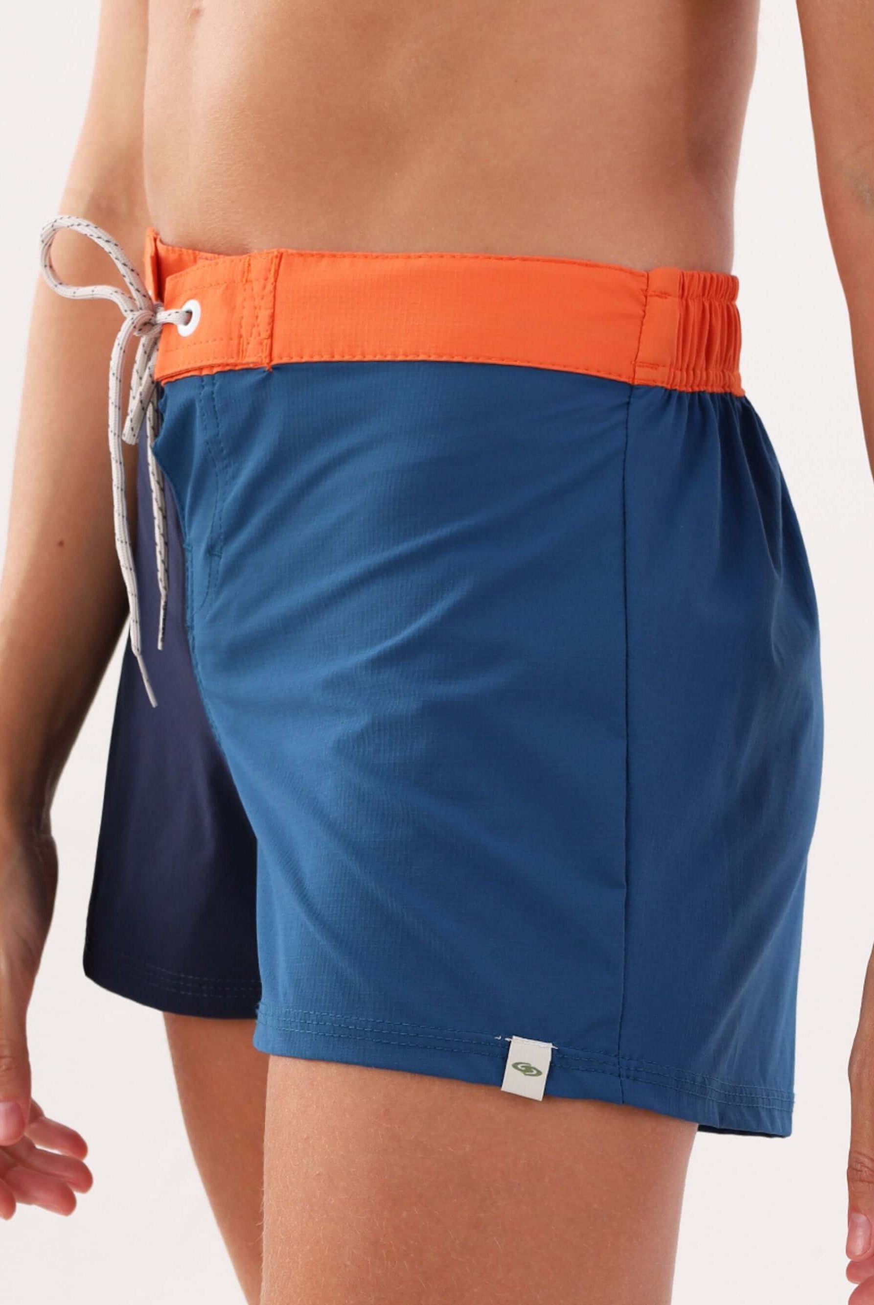 Short esportivo Talita da Greenish na cor azul marinho e laranja, ideal para atividades ao ar livre.