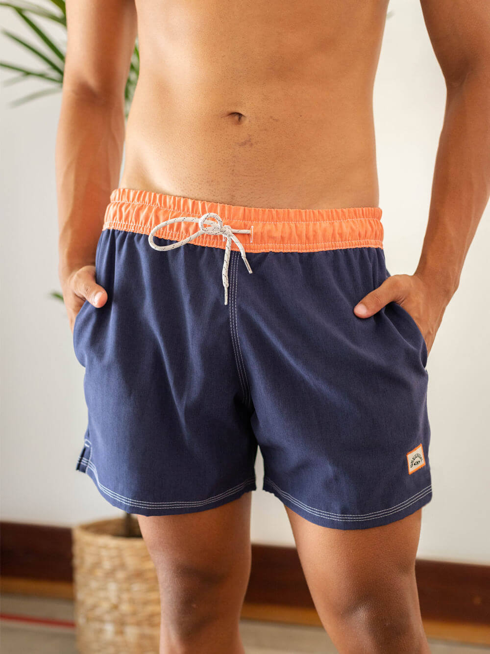 Short de vôlei azul marinho da Greenish, com detalhes em laranja, ideal para esportes e momentos à beira-mar.