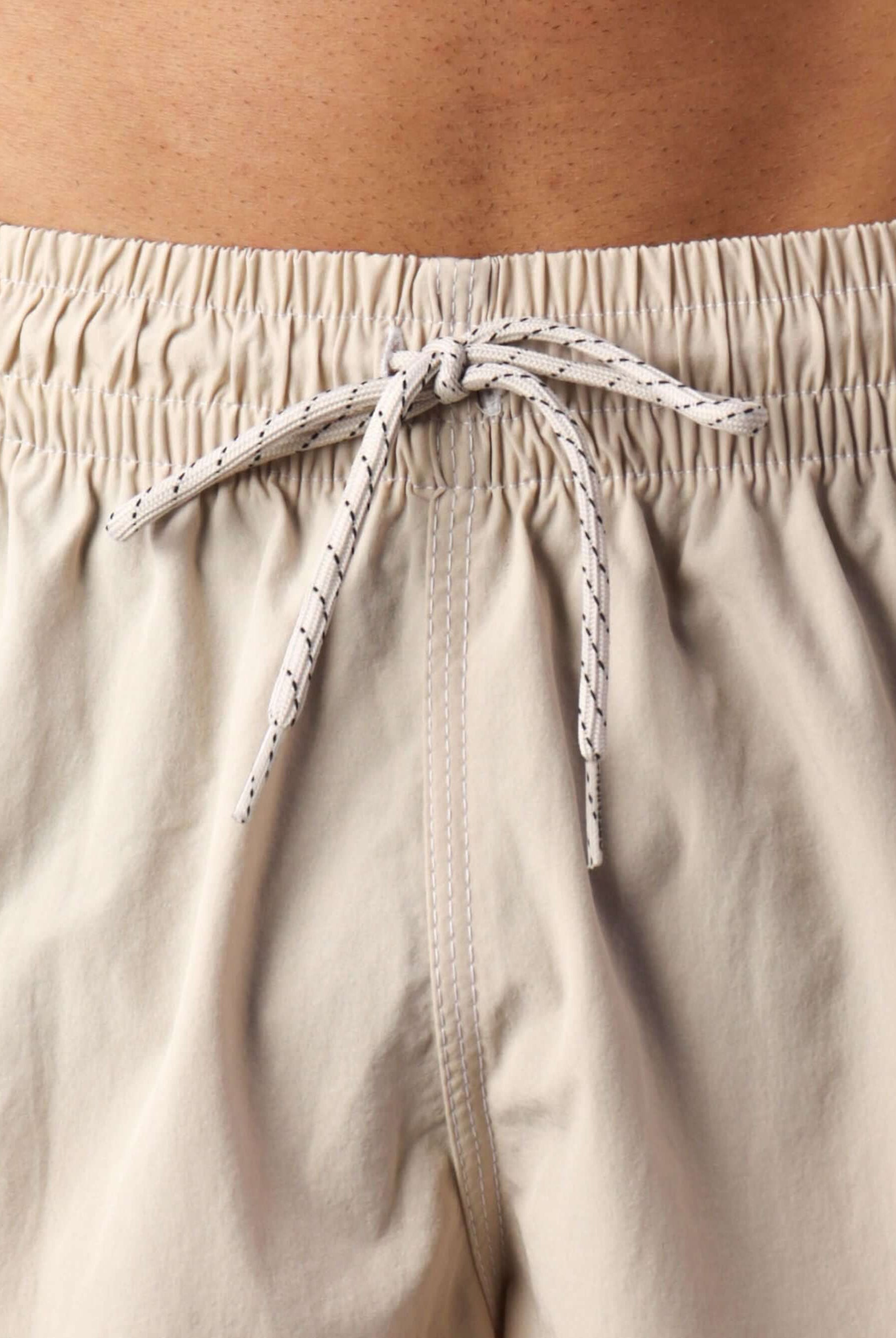 Detalhe do cós elástico do Short Volley Vintage Seekers Areia da Greenish, mostrando o laço e textura do tecido.