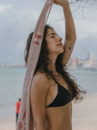 Modelo usando Sutiã Bíquini Hike da Greenish na praia com um longo lenço, aproveitando o sol.