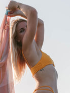 Modelo usando o Sutiã Biquíni Ophelia Laranja da Greenish, com tecido confortável e design minimalista.