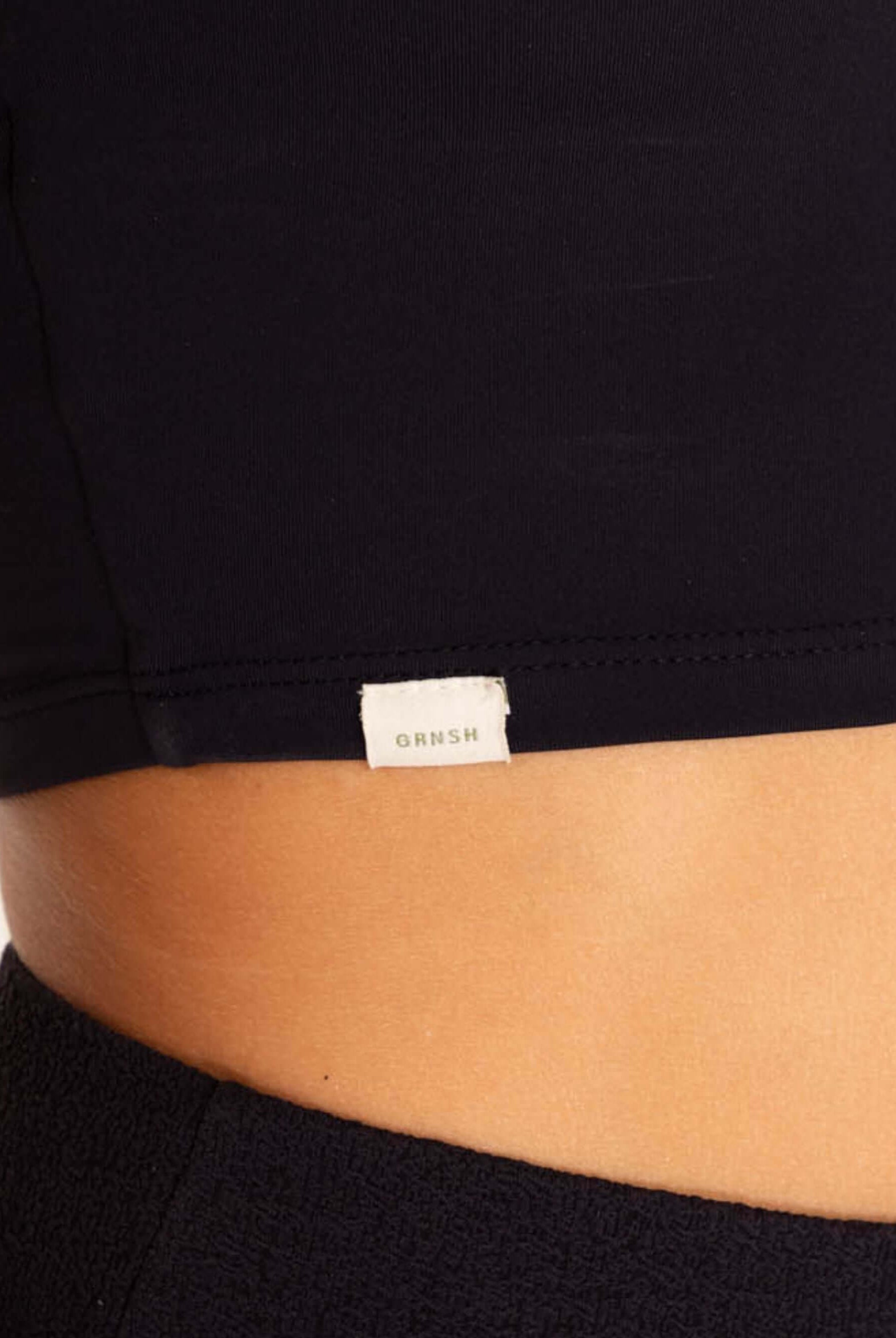 Camisa preta da Greenish com detalhe da etiqueta, ideal para atividades físicas.