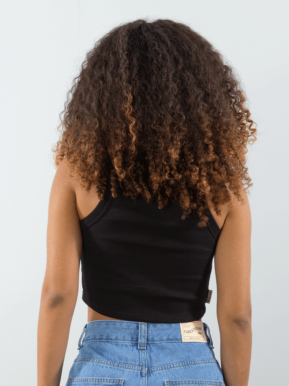 Top cropped básico em ribana preto da marca Greenish, modelo visto de costas, destacando o estilo casual.