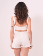 Mulher de costas vestindo Top Nalu Bege da Greenish, essencial para looks descontraídos com conforto e firmeza.