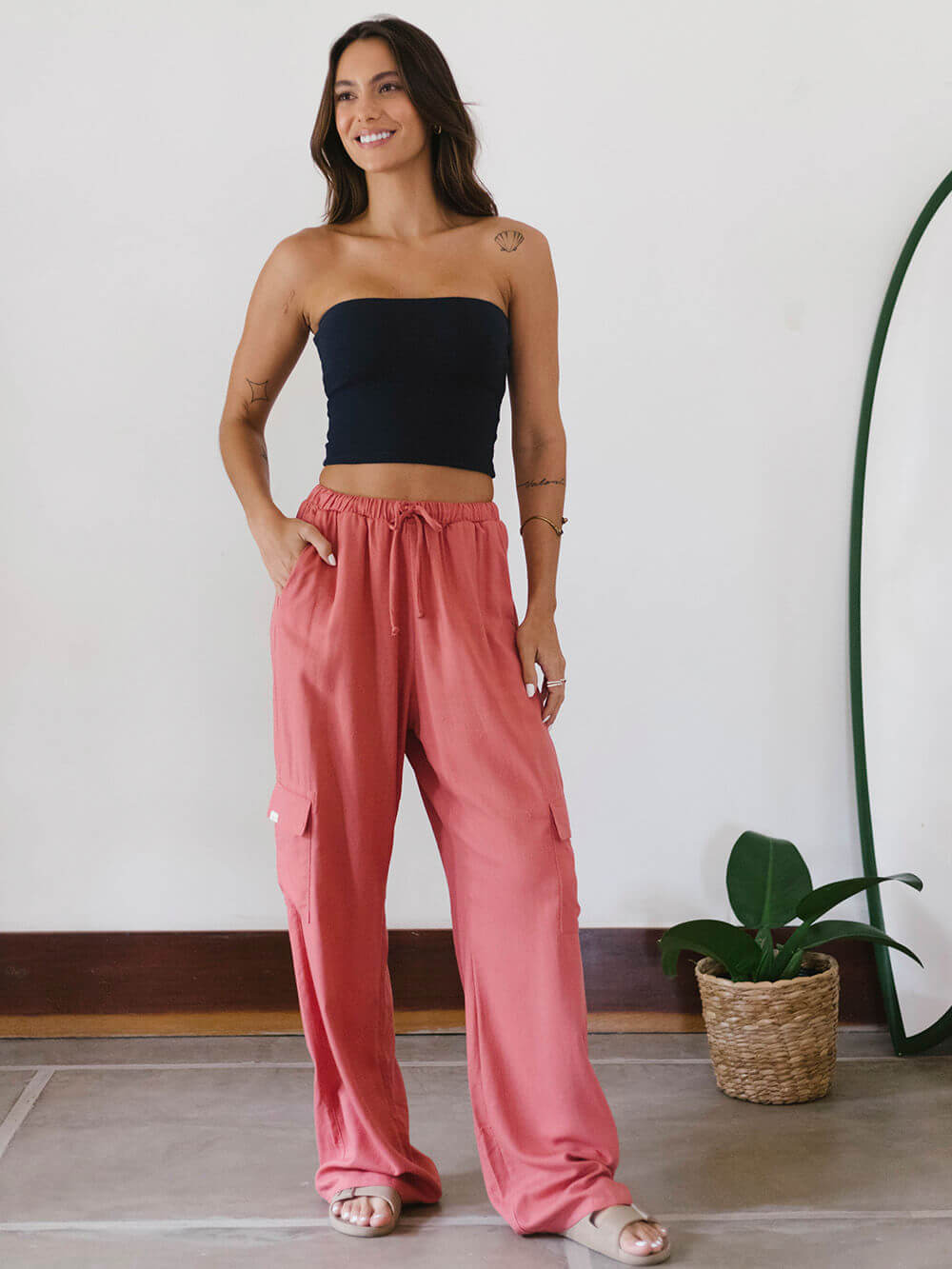 Modelo usando o Top Reto Valerie azul marinho da Greenish, com calça rosa, em ambiente minimalista.