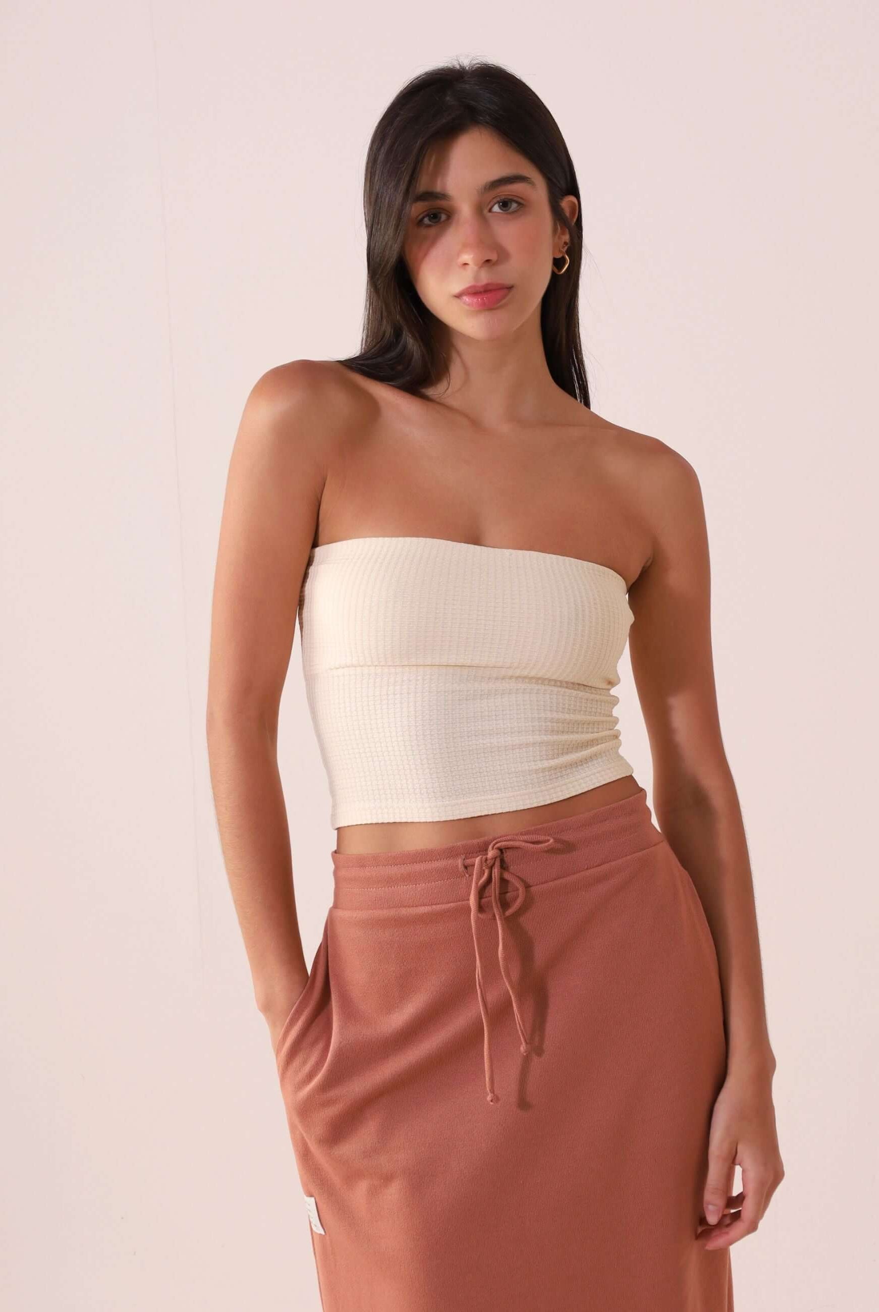 Modelo usando TOP RETO VALERIE - OFF WHITE da Greenish, sem alças, decote reto, feito de algodão sustentável, estilo minimalista.