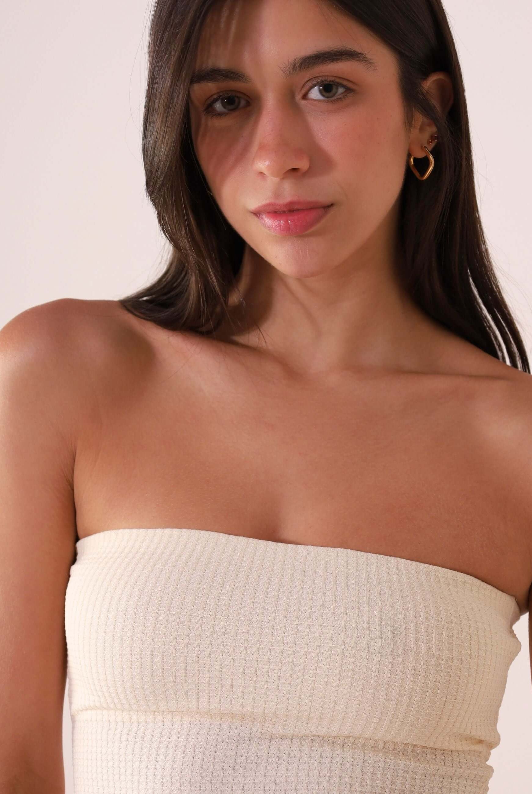 Modelo vestindo TOP RETO VALERIE - OFF WHITE da marca Greenish, top sem alças de algodão sustentável com estilo minimalista.