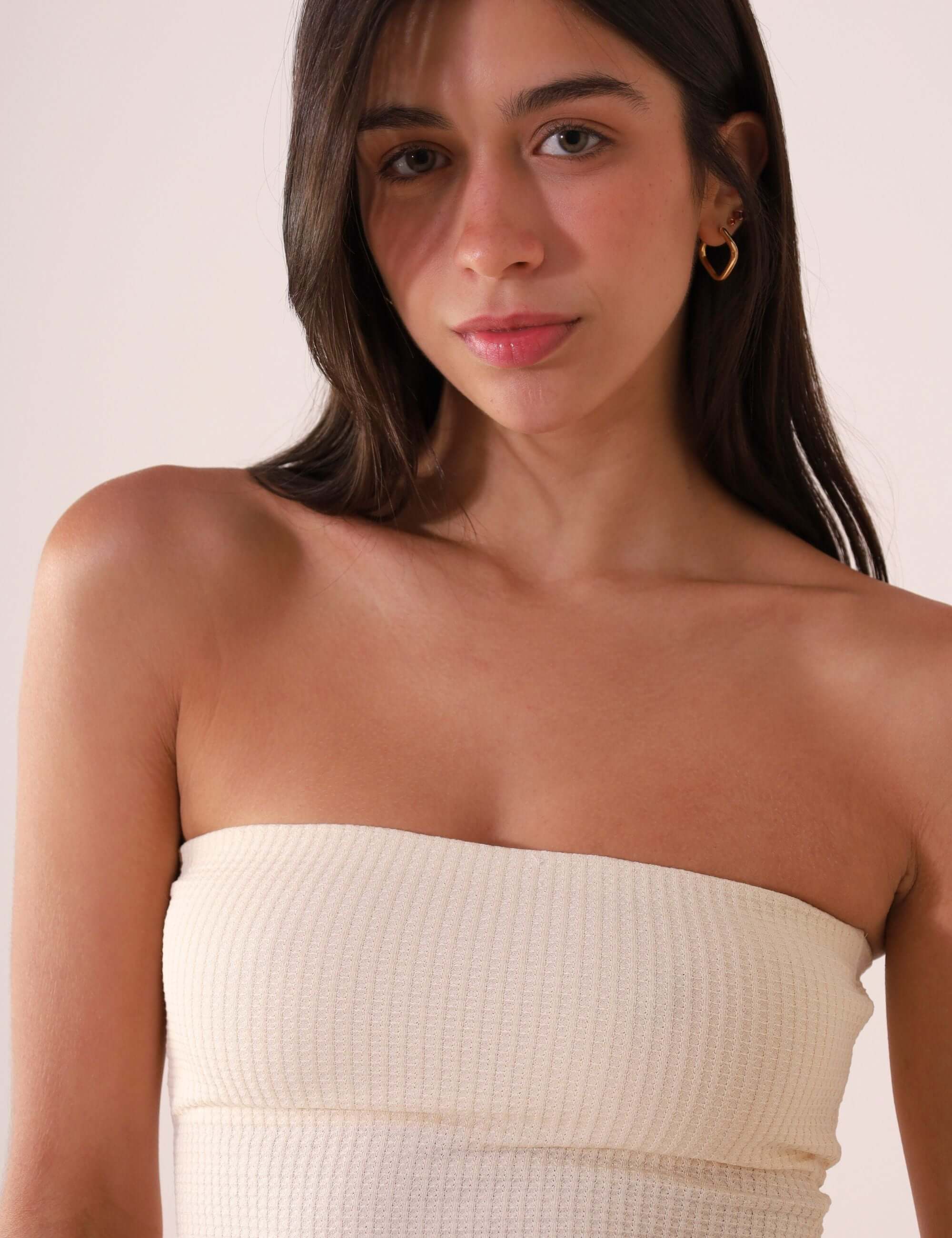 Modelo vestindo TOP RETO VALERIE - OFF WHITE da marca Greenish, top sem alças de algodão sustentável com estilo minimalista.