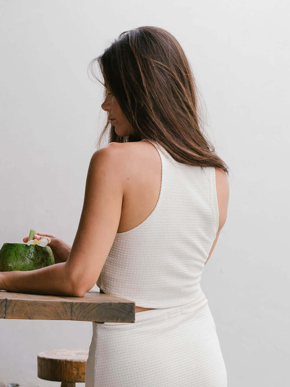 Modelo usando top tricot Issy Bege da Greenish, destacando o estilo cropped e tecido texturizado.