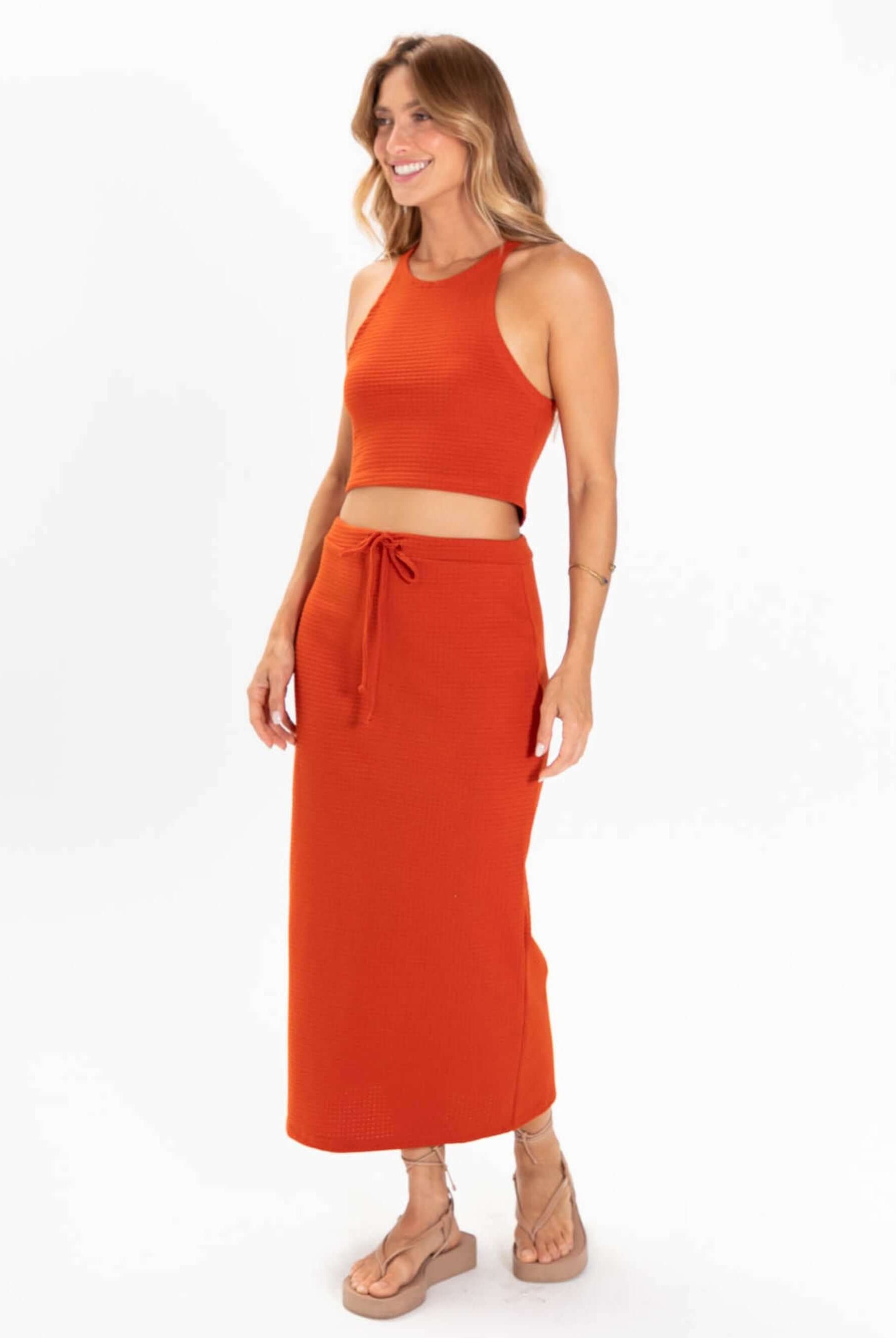 Top tricot Issy da Greenish em cor laranja, com cropped estilo regatinha e saia longa, perfeita para looks versáteis.