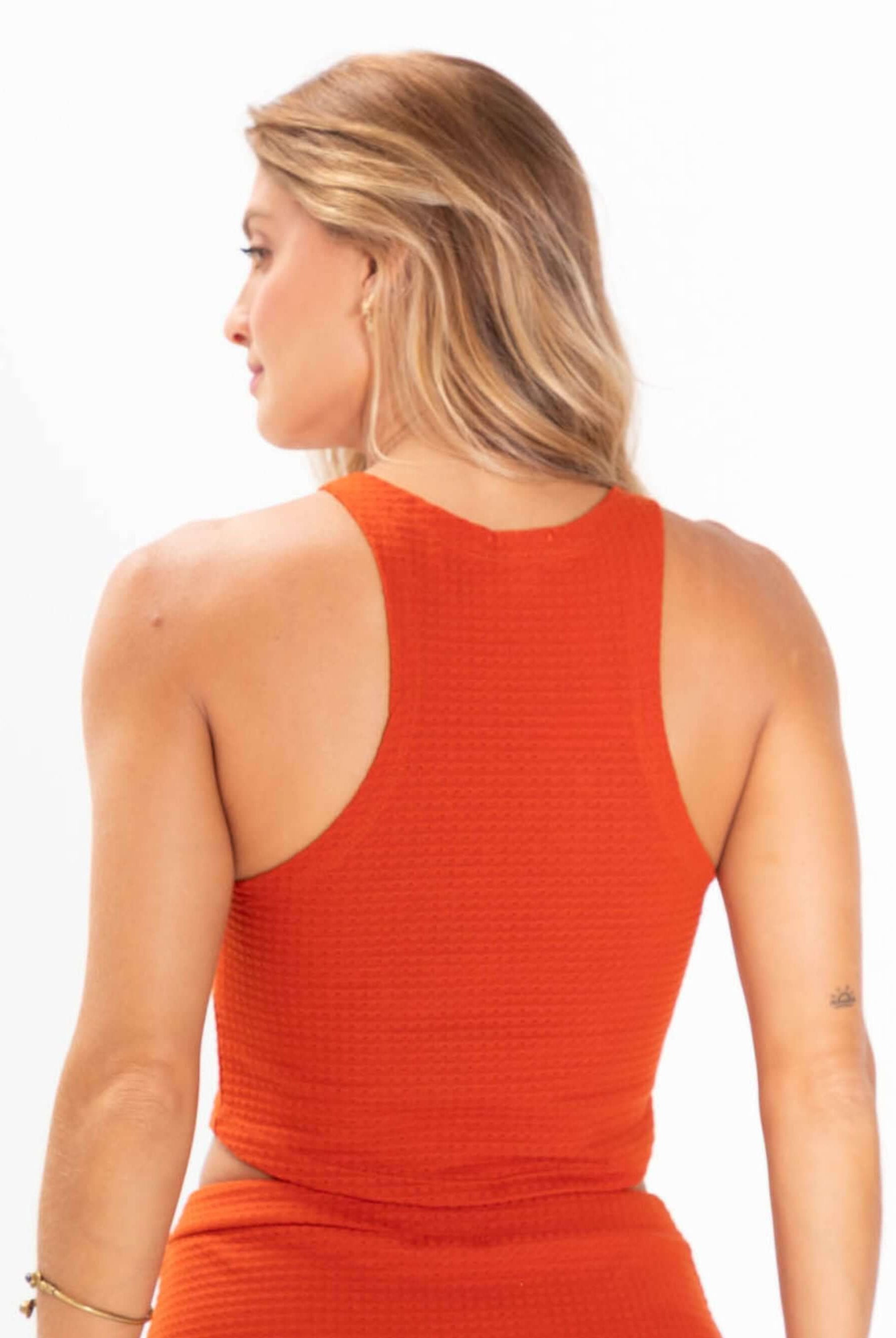 Top tricot Issy da Greenish, modelo cropped laranja com design de regatinha, vista posterior.