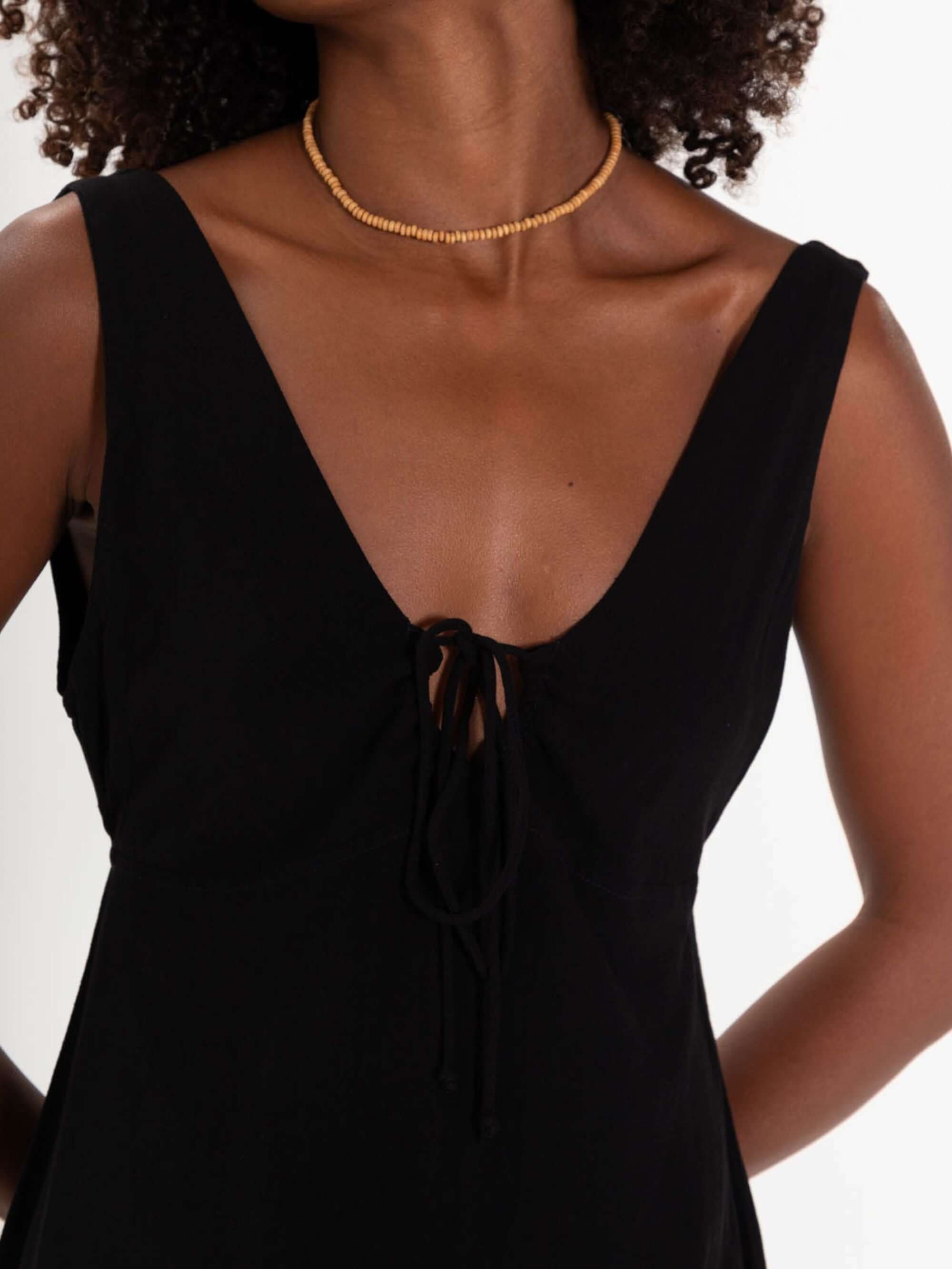 Vestido curto preto Elsa da Greenish com decote em V e laço, ideal para looks modernos e elegantes.