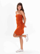 Vestido curto Jaya telha da Greenish, modelo strapless com detalhe franzido e fenda, perfeito para o verão.