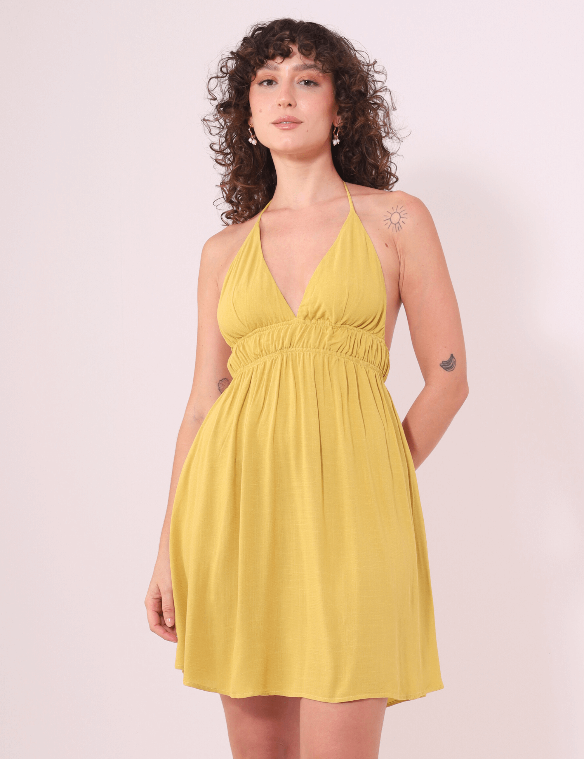 Vestido Curto Lara amarelo pistache da Greenish, feito em malha 100% viscose com busto duplo, ideal para dias tranquilos ou passeios.