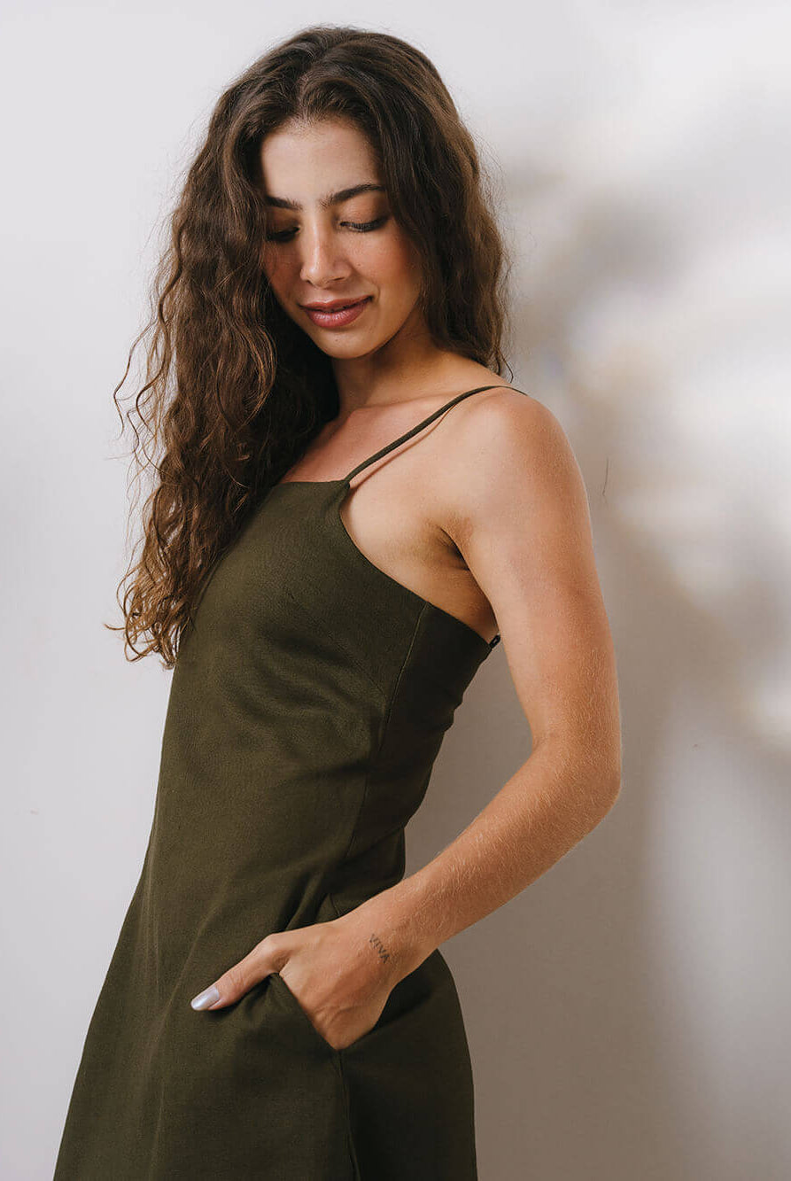 Modelo usando o vestido curto Maggie verde da marca Greenish, com caimento elegante e bolsos laterais.