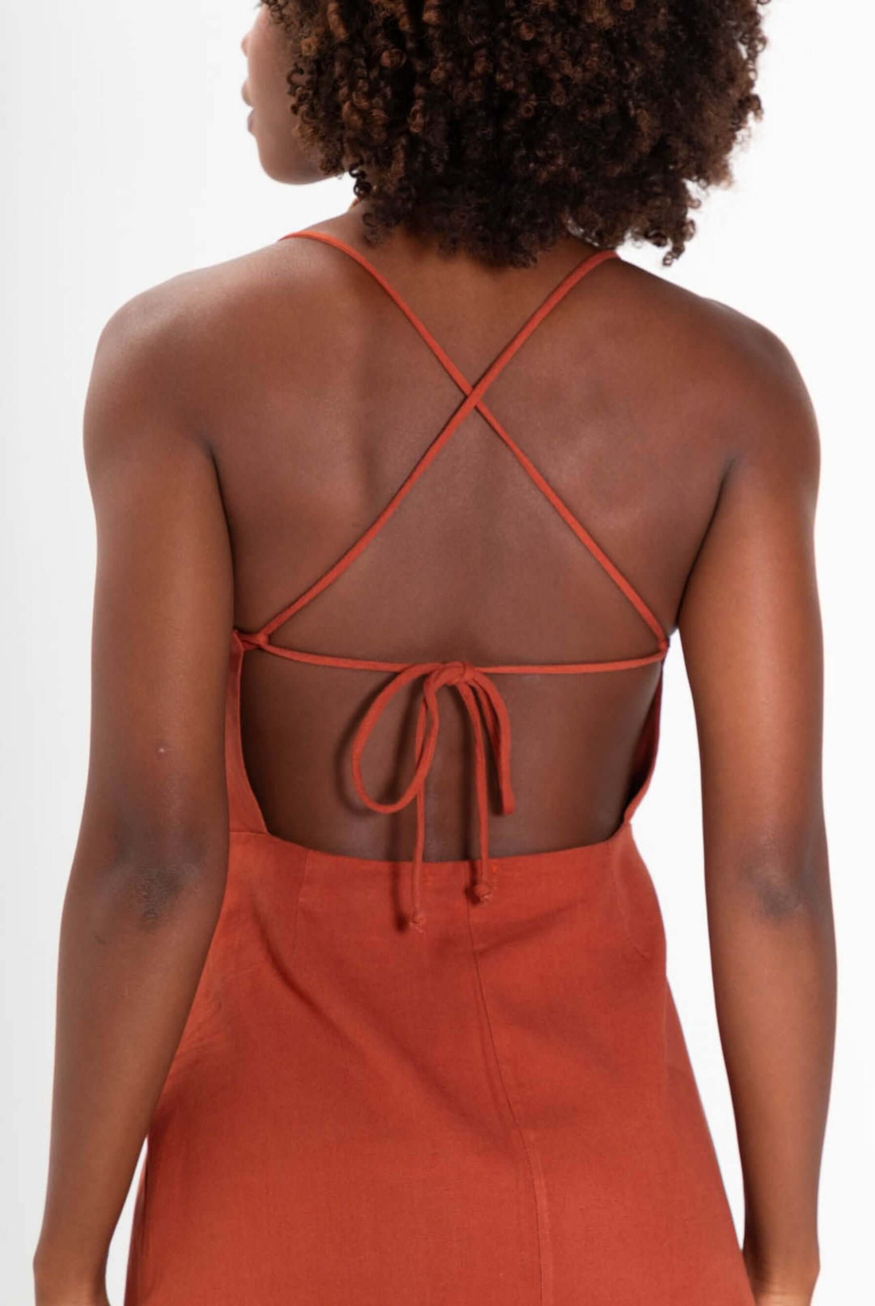 Detalhe das costas do vestido curto Milly da Greenish, com alças cruzadas e amarração, em tom marrom.