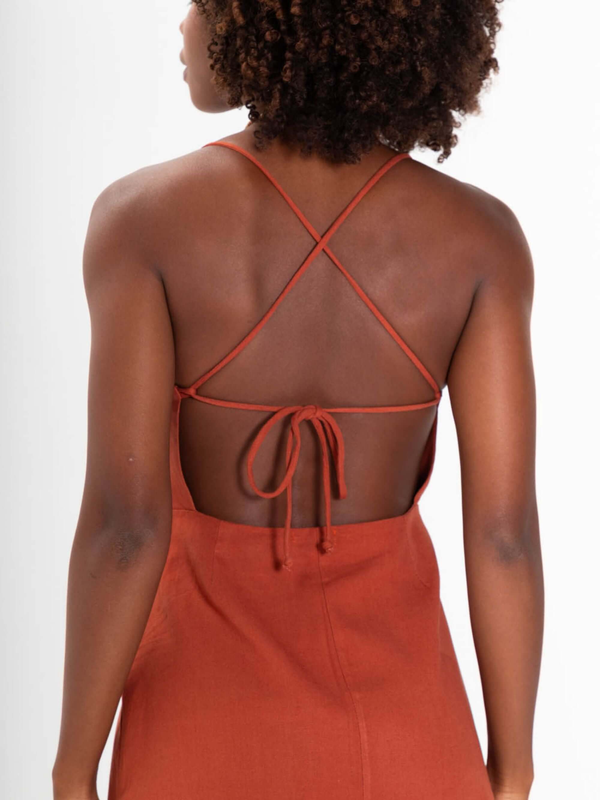 Detalhe das costas do vestido curto Milly da Greenish, com alças cruzadas e amarração, em tom marrom.