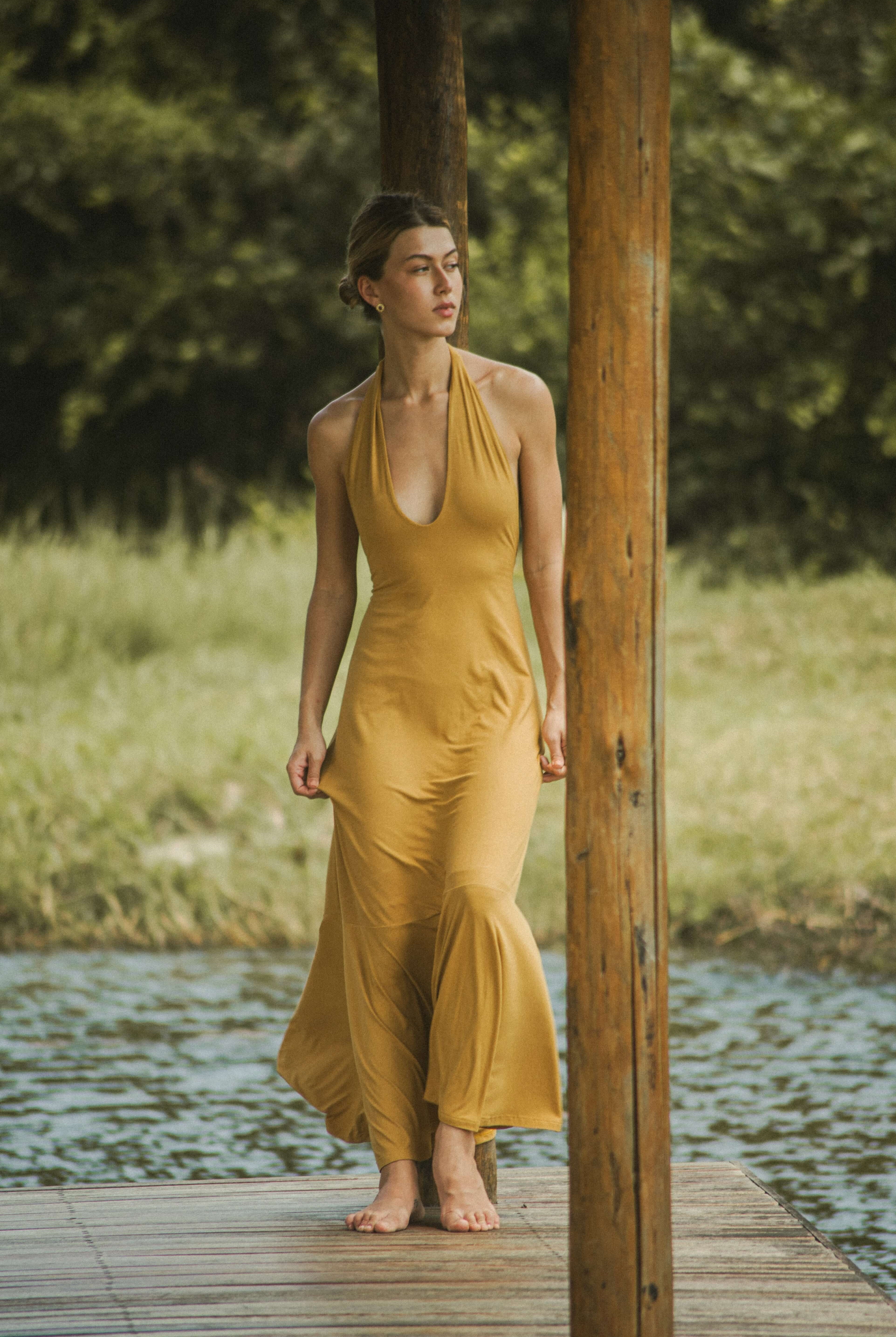 Vestido Longo Serena - Caqui da Greenish, modelo fluido e elegante, com decote profundo, ideal para dias quentes e momentos casuais.