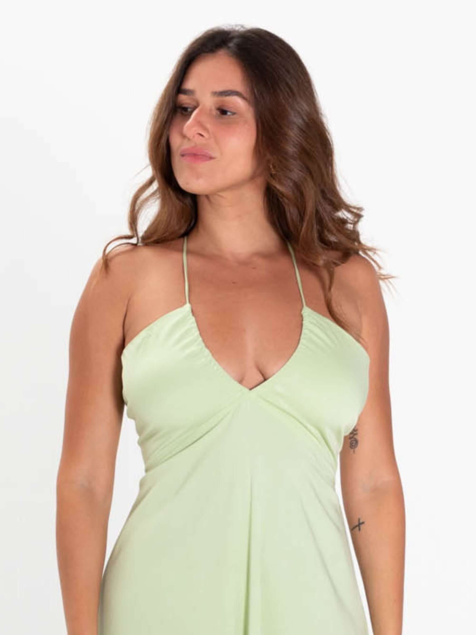 Modelo usando vestido midi verde claro da Greenish, com decote em V e alças finas, ideal para verão.