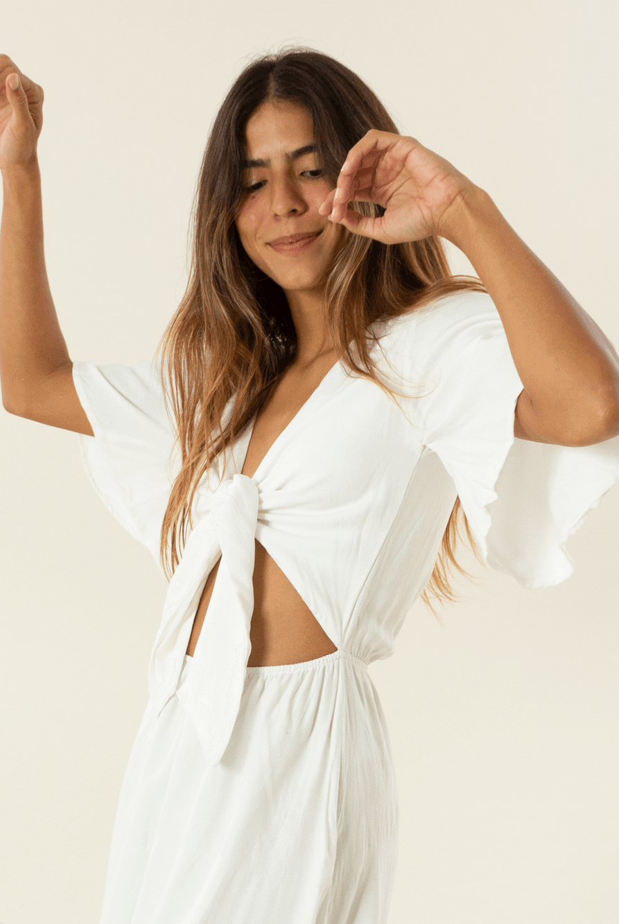 Modelo usando vestido midi Capri off white da marca Greenish, com mangas largas e detalhes elegantes.