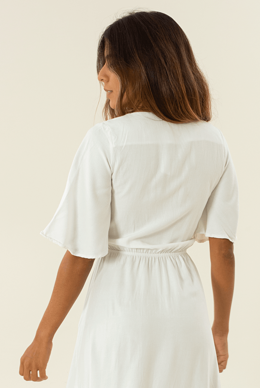 Modelo usando vestido midi Capri off white da marca Greenish, vista traseira, elegância e conforto.