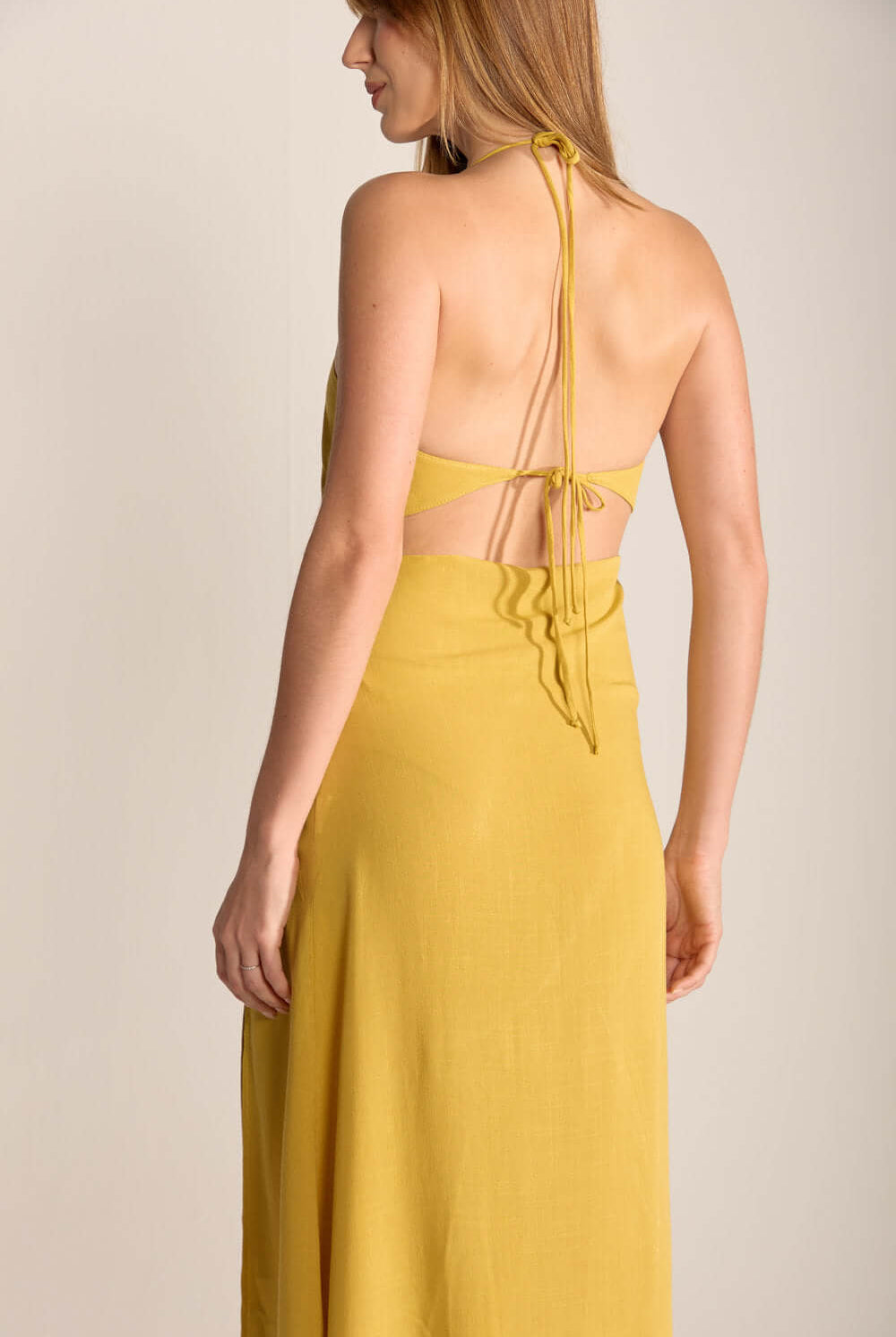 Vestido Midi Ju da Greenish em amarelo pistache, com detalhes nas costas e caimento leve.