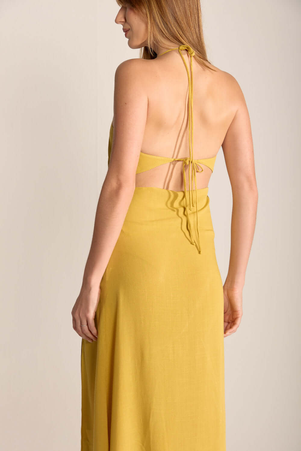 Vestido Midi Ju da Greenish em amarelo pistache, com detalhes nas costas e caimento leve.