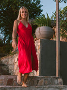 Modelo usando vestido midi vermelho Bordo da Greenish, com decote V e amarração lateral em ambiente natural.