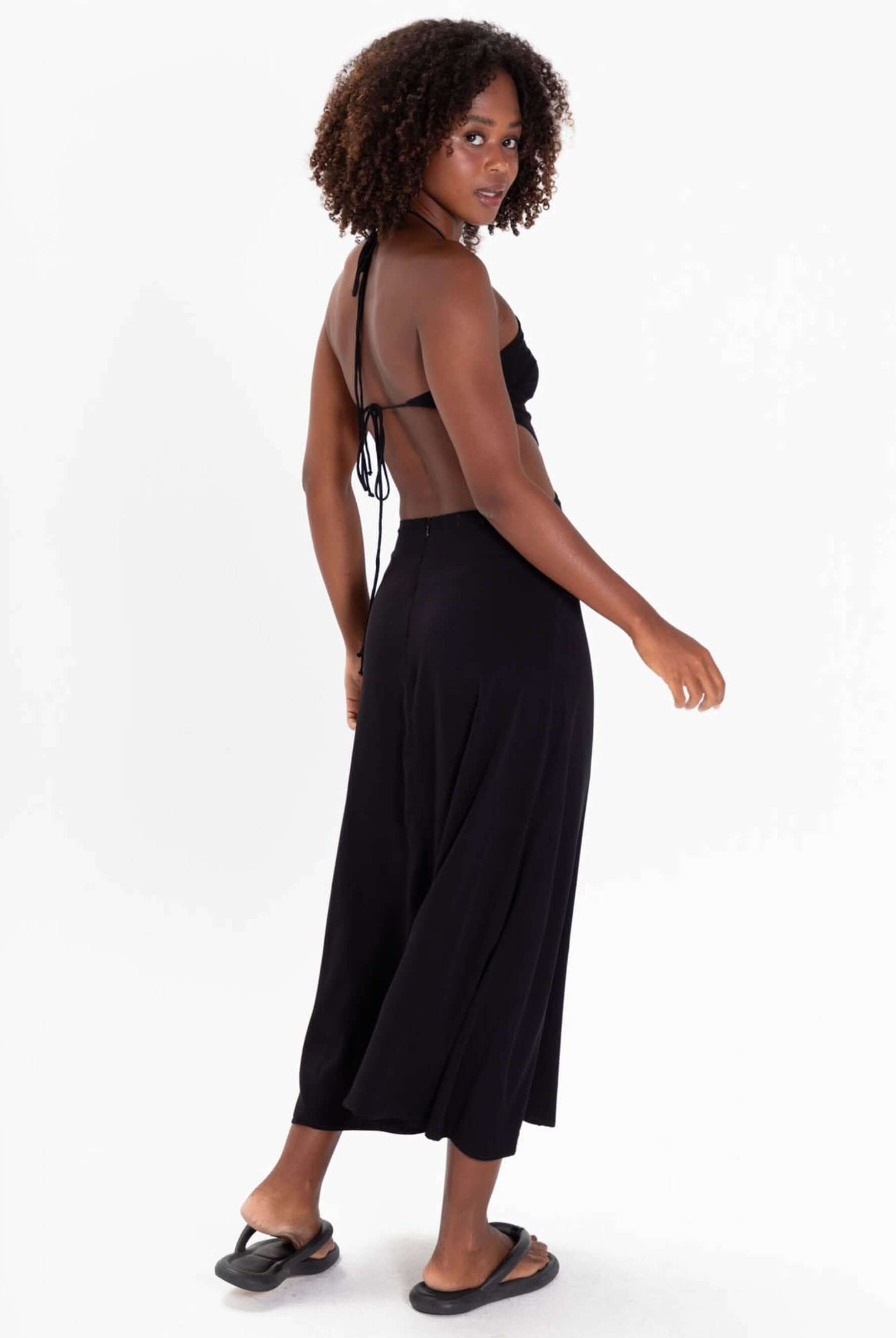 Modelo usando o Vestido Midi Yana da Greenish, preto, com detalhes de amarração e costas nuas.
