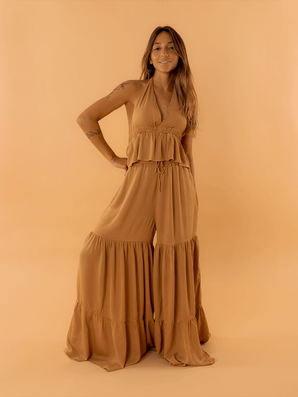 Mulher usando conjunto de duas peças em tom caqui, com blusa e calça ampla, estilo fashion da marca Greenish.