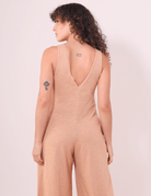 Mulher vestindo Macacão Lais Laranja com decote em V nas costas da Greenish, estilo leve e conforto para o verão.