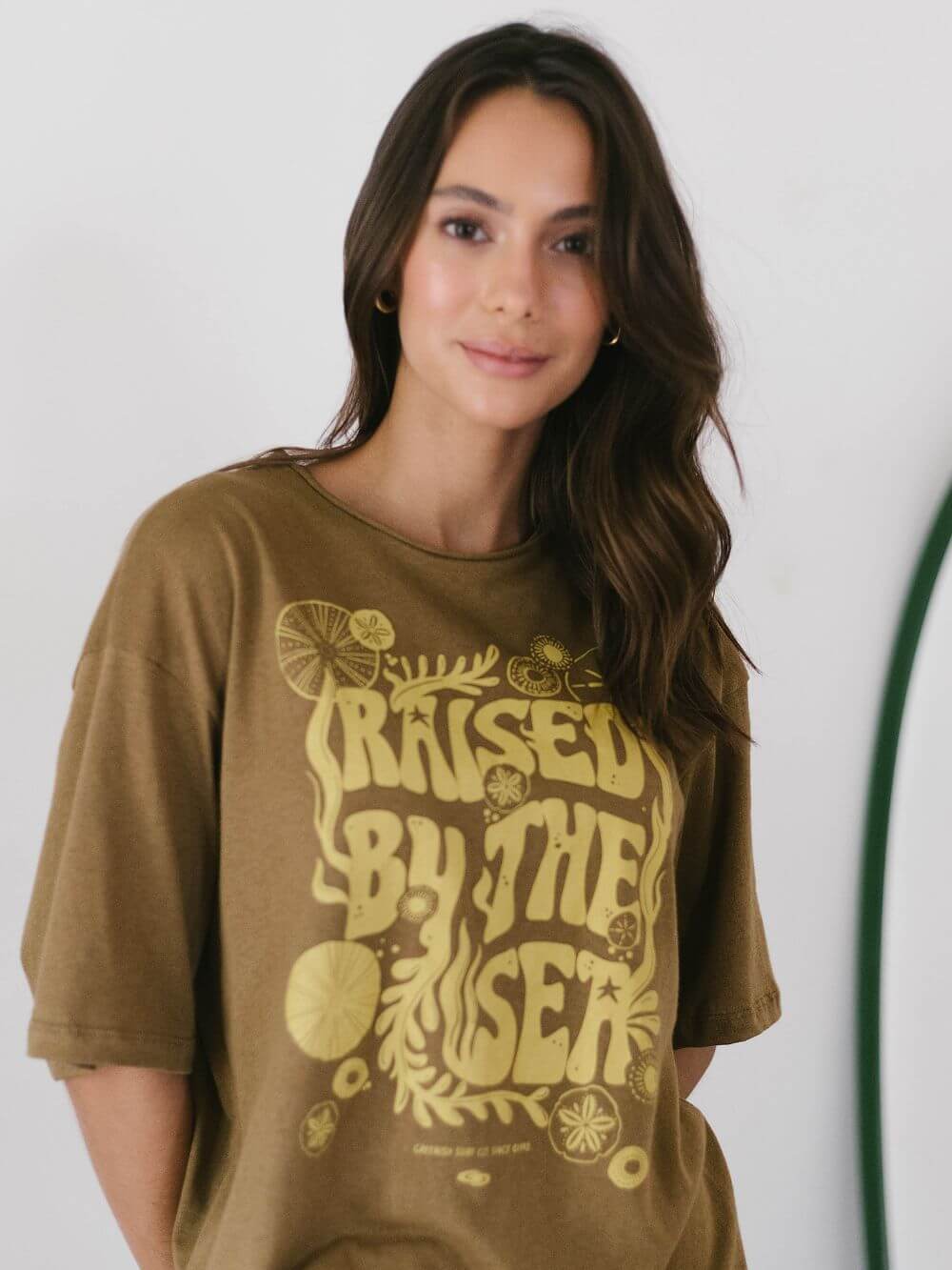 Camiseta oversized Raised By The Sea da Greenish, em caqui, com estampa exclusiva e vibe street.