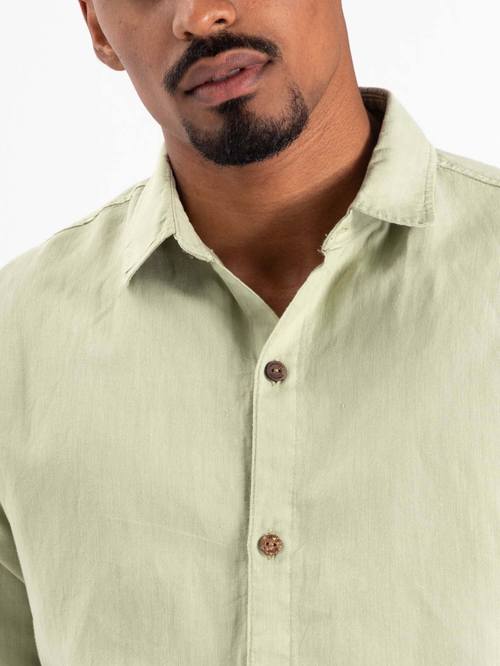 Camisa botão hemp canhamo verde da marca Greenish, com botão marrom e tecido leve, ideal para o verão.