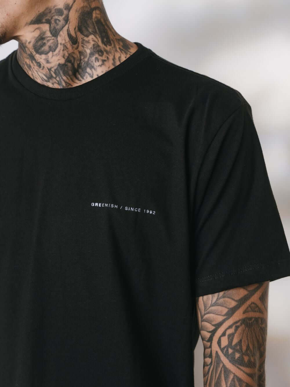 Camiseta preta da Greenish com estampa minimalista, ideal para surf e estilo casual.