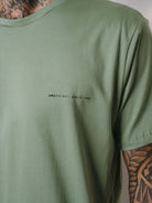 Camiseta Greenish verde com estampa discreta "Greenish Since 1992", perfeita para surfistas e amantes de moda.